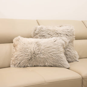 Two New Zealand sheepskin cushions in pale grey displayed on a beige sofa