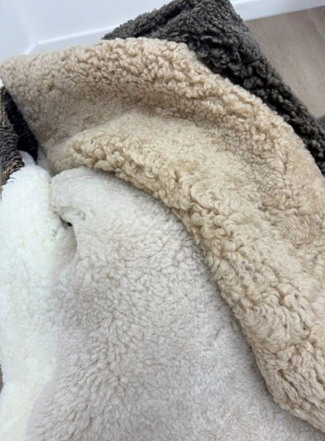 Oatmeal shearling rug colour collection featuring Oatmeal, Natural White, Honey and Chocolate Fleck sheepskin rugs.