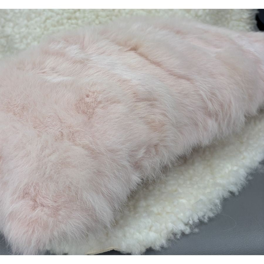 Close-up of soft pink rabbit fur cushion showing plush natural texture