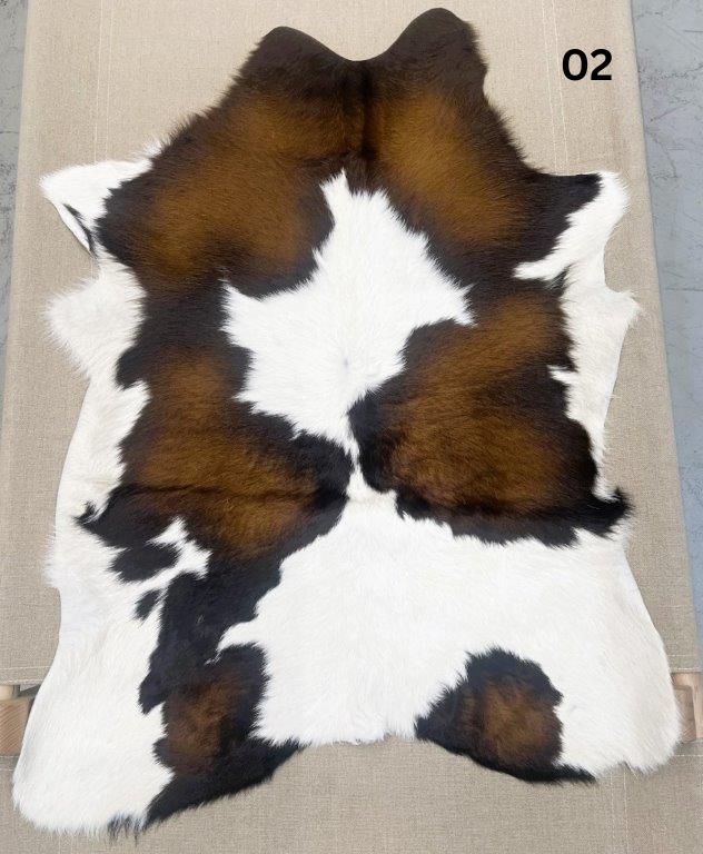 Reddish brown calf hide rug number 02 with natural markings and central white pattern on a neutral background