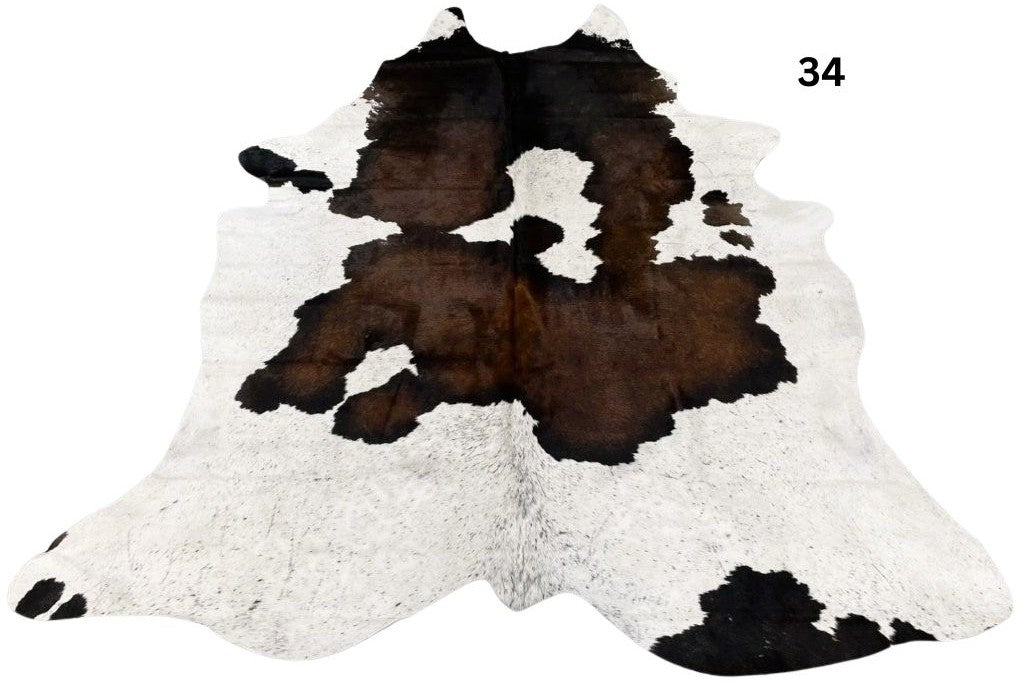 Reddish brown and white cowhide rug number 34 with natural markings and speckled pattern on a white background