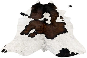Reddish brown and white cowhide rug number 34 with natural markings and speckled pattern on a white background