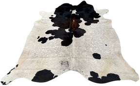 Reddish brown and white cowhide rug with natural markings and smooth hair on a white background