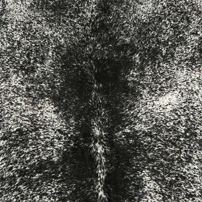Close-up detail of a salt and pepper cowhide rug showing speckled pattern and smooth natural hair texture