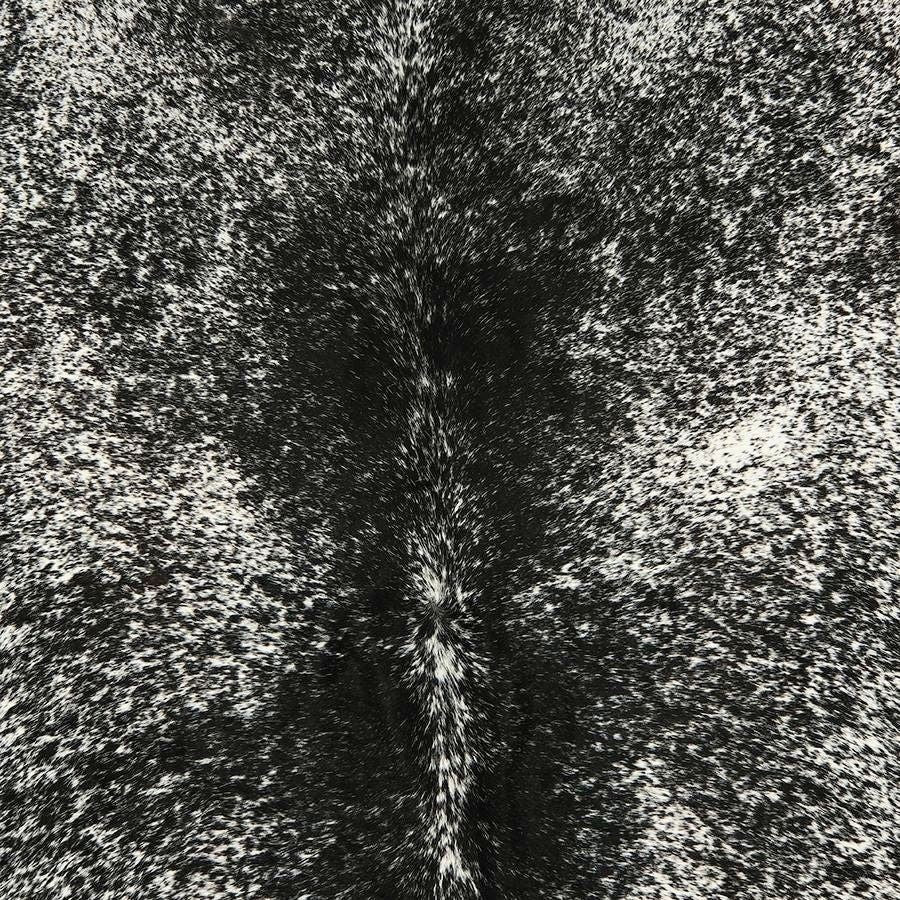 Close-up detail of a salt and pepper cowhide rug showing speckled pattern and smooth natural hair texture