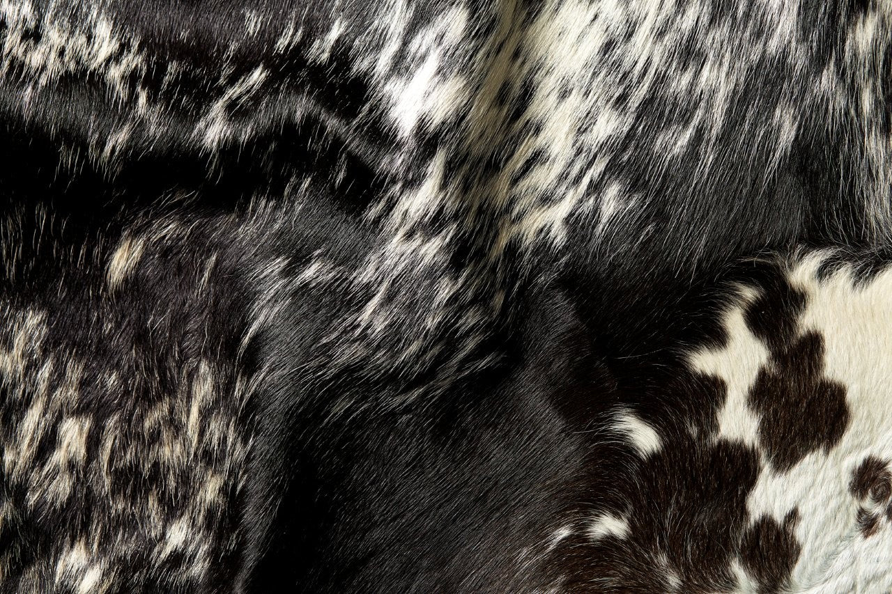 Close-up detail of natural salt and pepper cowhide rug showing black and white hair texture and markings