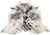 Speckled longhorn cowhide rug example showing natural markings and tonal variation on a white background