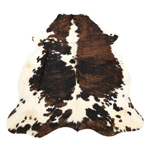 Tri colour cowhide rug example showing natural tonal variation and markings on a white background