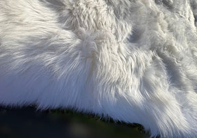 Close-up detail of white merino sheepskin rug showing natural wool texture