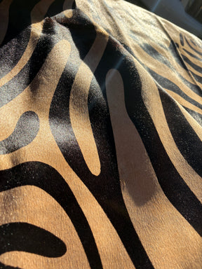 Close-up detail of zebra print cowhide rug showing black pattern on natural beige hide with hair-on-hide texture
