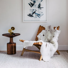 Albino spotted reindeer hide throw draped over a chair showing light natural hair and distinctive spotted markings