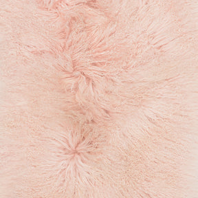 Close-up detail of blush Mongolian sheepskin cushion showing long, soft hair texture