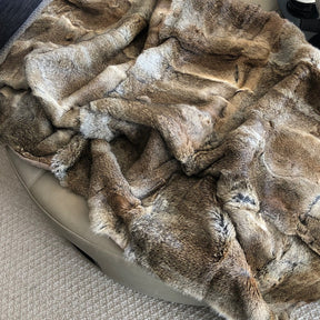 Brown rabbit hide blanket draped over a chair showing soft natural texture