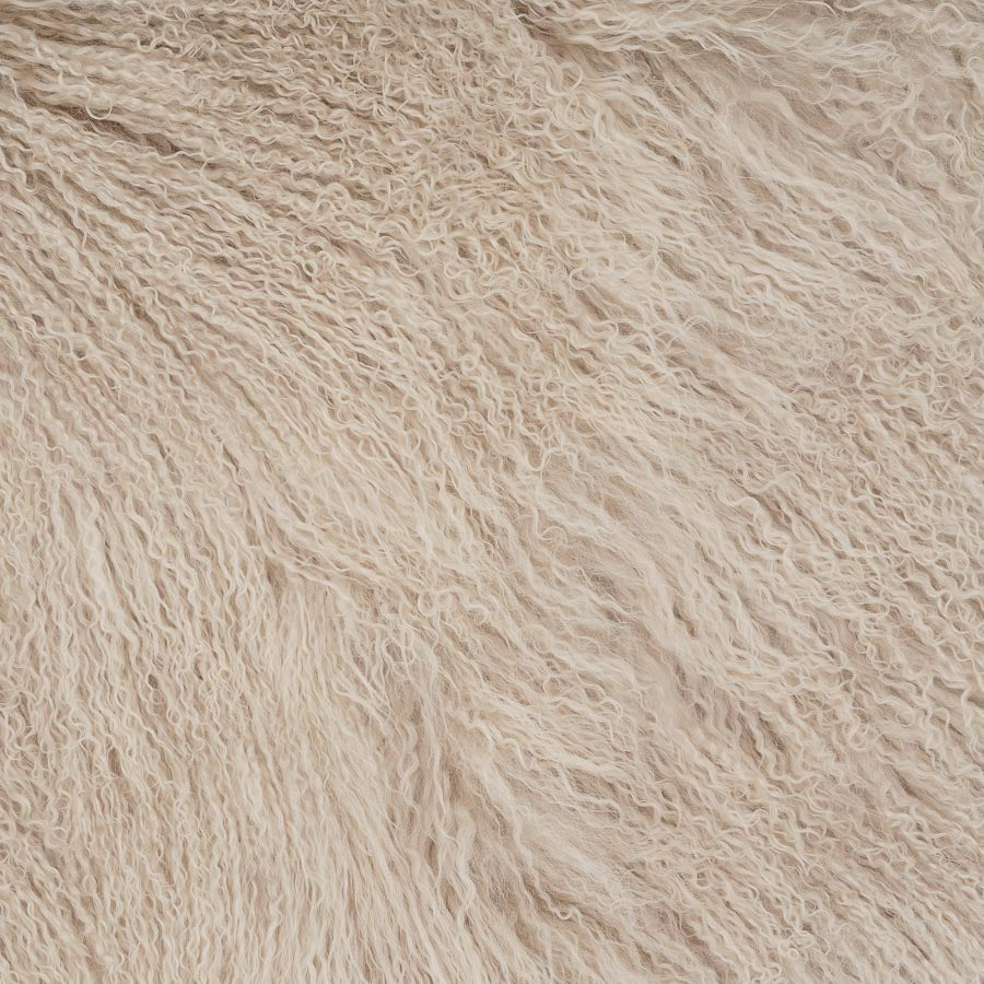 Close-up detail of fawn Mongolian sheepskin cushion showing long, soft hair texture