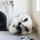 Icelandic sheepskin bean bag in natural black and white spot styled in a living room setting