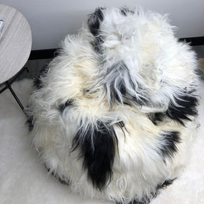 Top view of an Icelandic sheepskin bean bag in natural black and white spot showing long wool texture