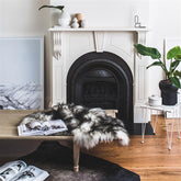 White Icelandic sheepskin rug with dark tips styled over furniture in a living space