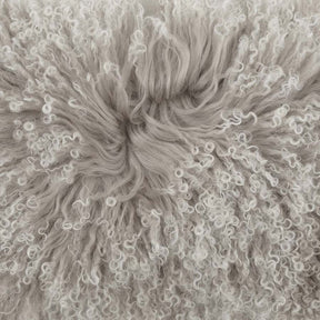 Close-up detail of grey Mongolian sheepskin cushion with white tips showing soft, silky long wool texture