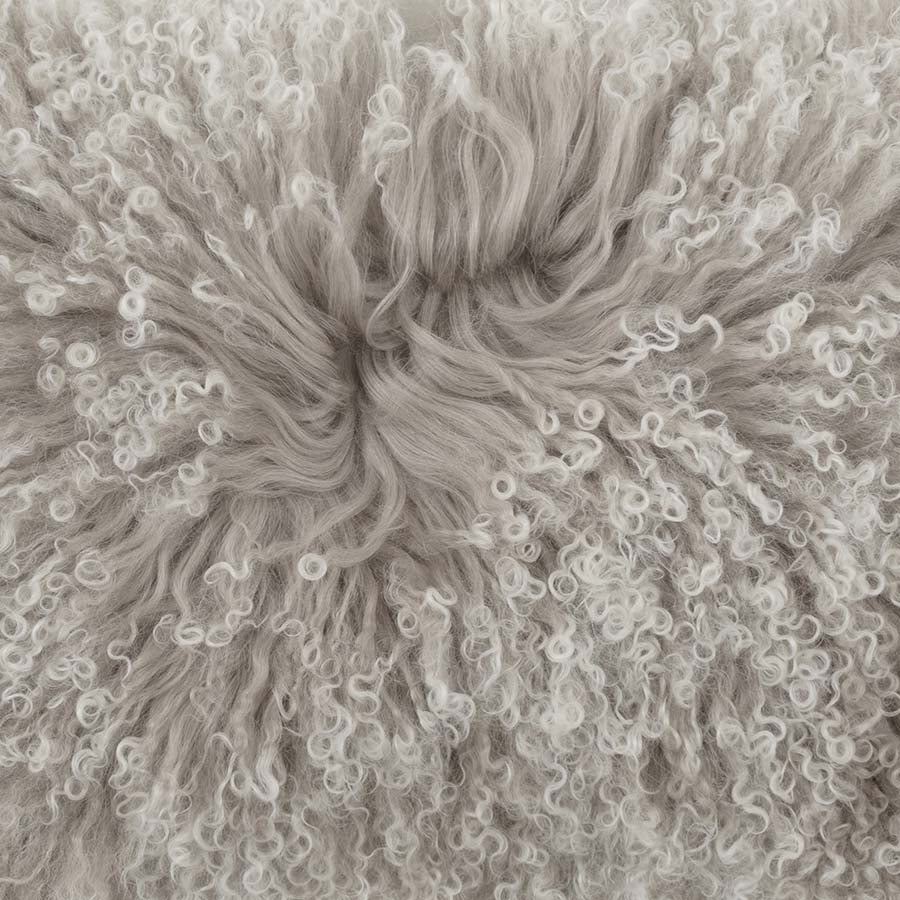 Close-up detail of grey Mongolian sheepskin cushion with white tips showing soft, silky long wool texture