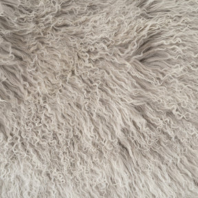 Close-up detail of grey Mongolian sheepskin with white tips showing soft, silky long wool texture