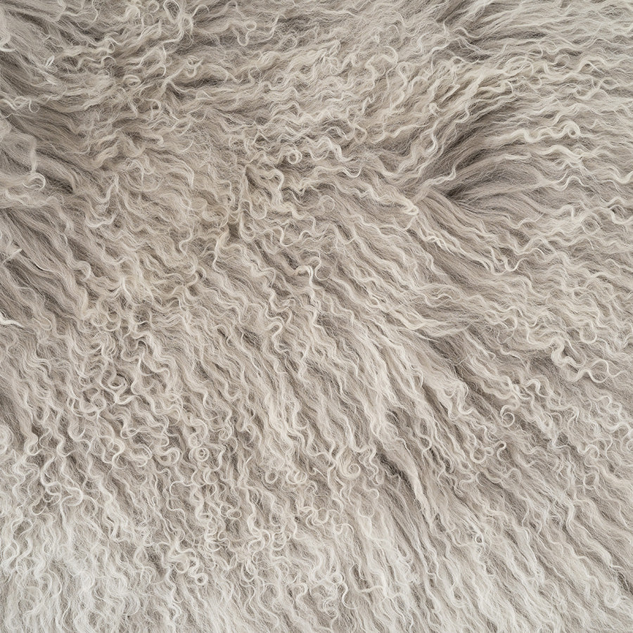 Close-up detail of grey Mongolian sheepskin with white tips showing soft, silky long wool texture