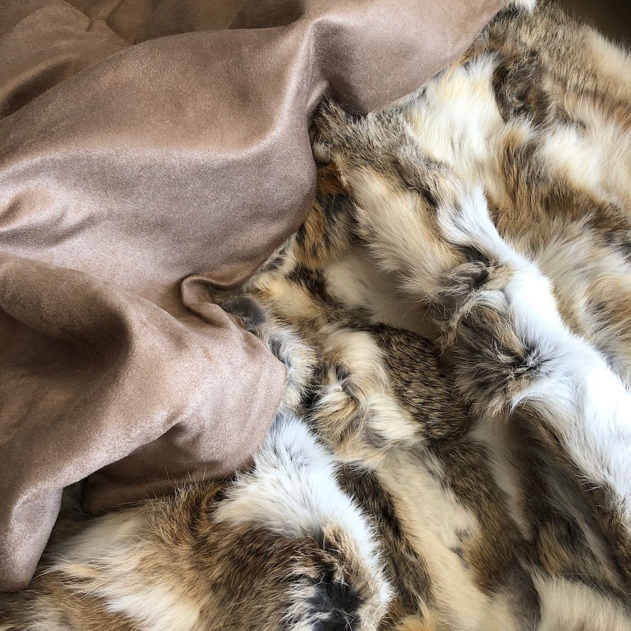 White and brown rabbit hide blanket showing cotton velour backing and natural hair edge