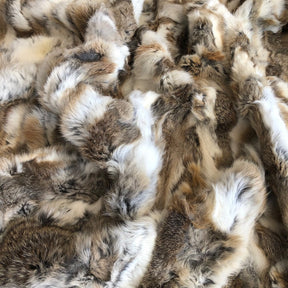 Close-up of white and brown rabbit hide blanket showing dense natural hair and tonal variation