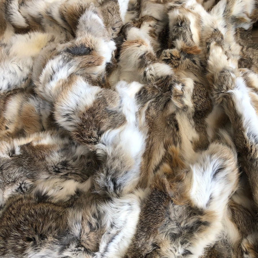Close-up of white and brown rabbit hide blanket showing dense natural hair and tonal variation