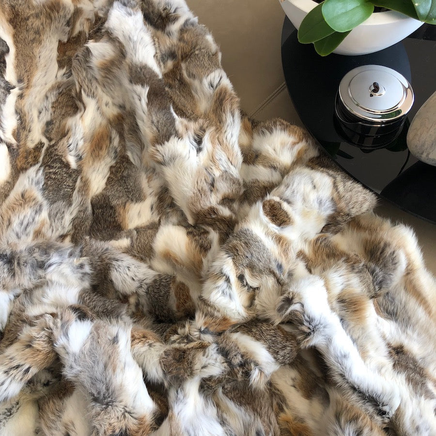 Close-up of white and brown rabbit hide blanket showing natural hair variation and texture