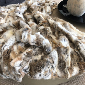 White and brown rabbit hide blanket spread across a surface showing naturally soft hair texture