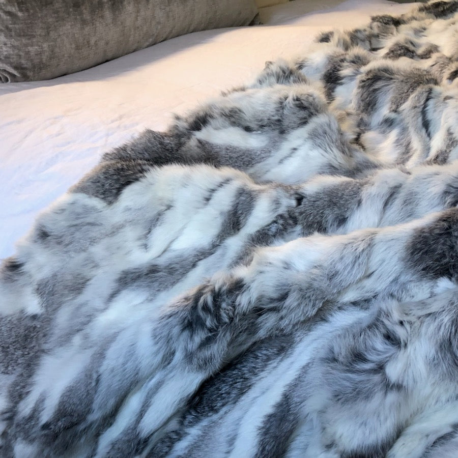 Close-up detail of white and grey rabbit hide blanket showing natural hair pattern and texture