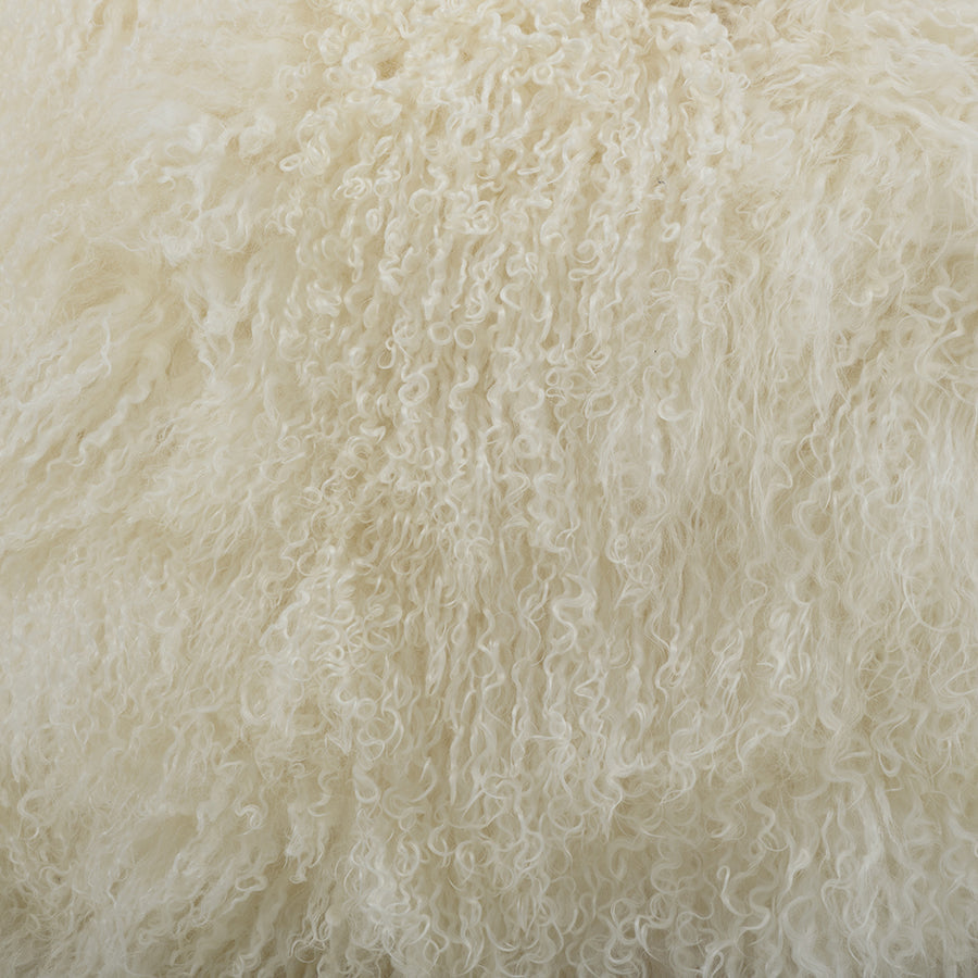 Close-up detail of white Mongolian sheepskin cushion showing long, soft hair texture