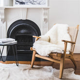 Icelandic shorn sheepskin rug in natural white styled over an armchair in a living room setting